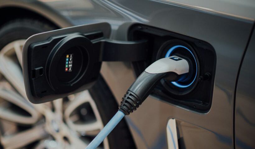 Electric car plugged into a charging cable for running cost comparison