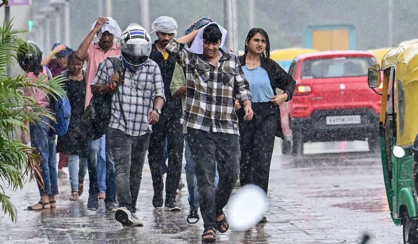 Pedestrians walking through rain in Bengaluru