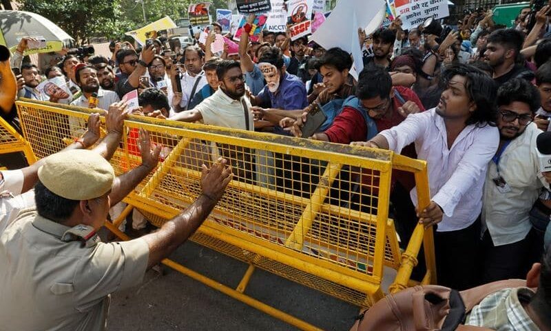 Protesters gathered behind a police barricade in India